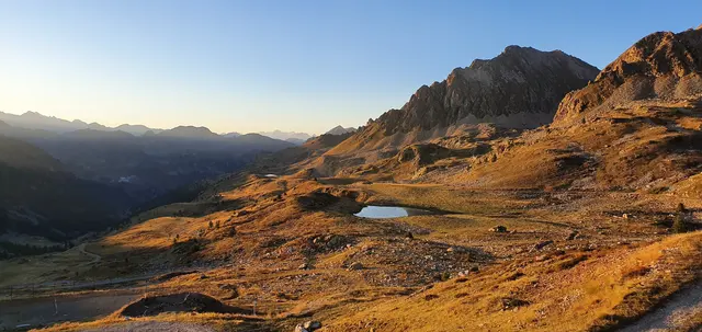 Horské údolí s jezerem v zapadajícím slunci