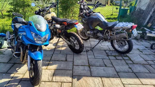 Motorrad-Service: drei geparkte Motorräder auf einem Pflasterhof