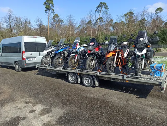 Transport motocykli na miejsce wyprawy dostawczakiem z przyczepą.