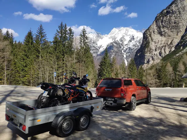 Transport motocykli na miejsce wyprawy: pickup z przyczepą w górach.