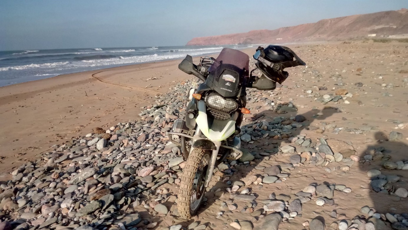 Motorka na kamenité pláži u oceánu